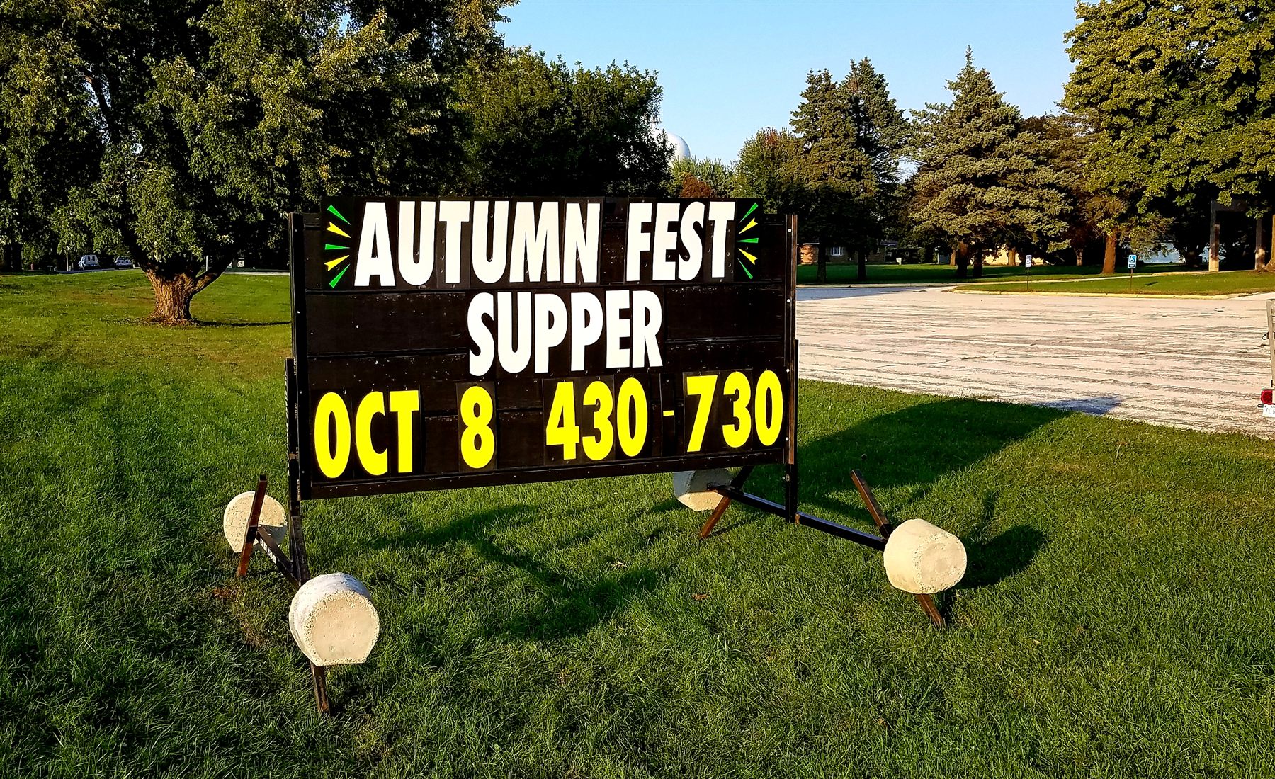 Portable roadside sign announcing an Autumn Fest supper
